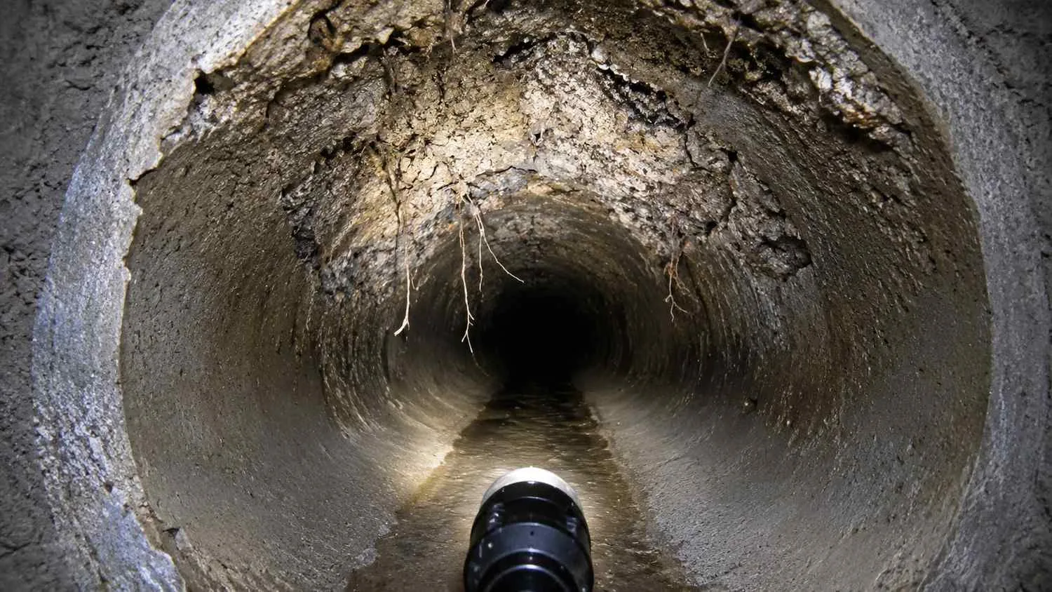 Cross-section of a deteriorated Florida concrete sewer pipe showing hydrogen sulfide crown corrosion and structural degradation.